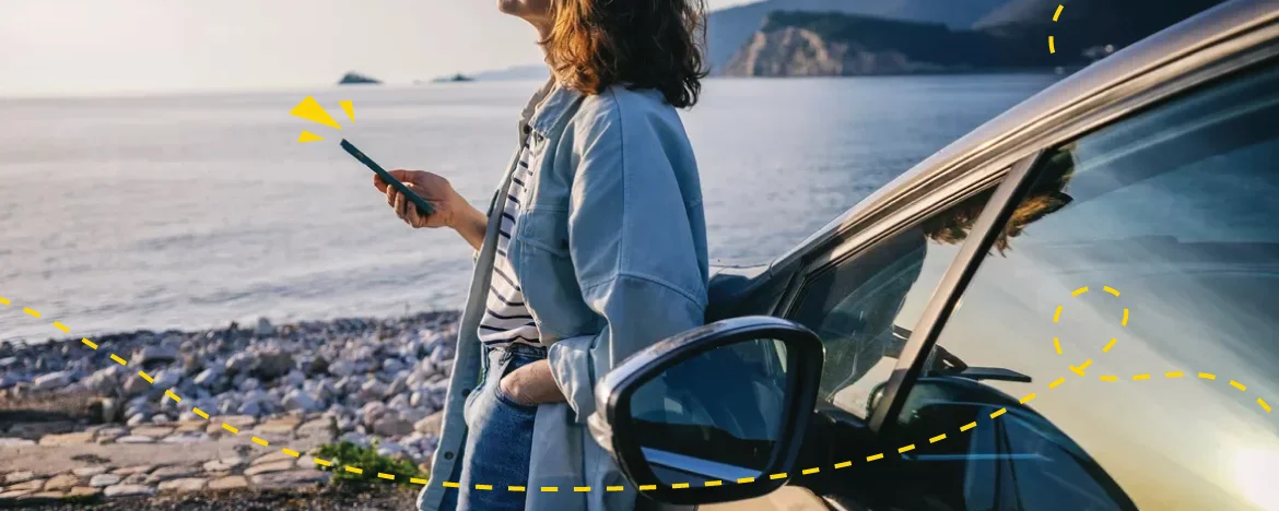 person on phone stood outside car