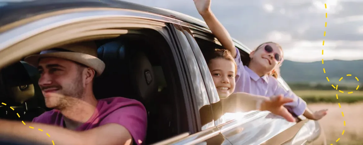 man driving, kids in back with heads out window